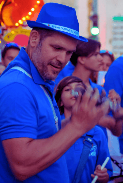Homme en bleu aux couleurs de Los Cumbancheros qui fais des percussions brésiliennes