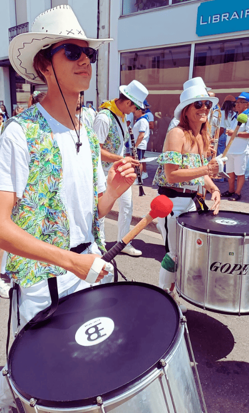 Un jeune homme qui joue du tambour avec le groupe des cours de percussions